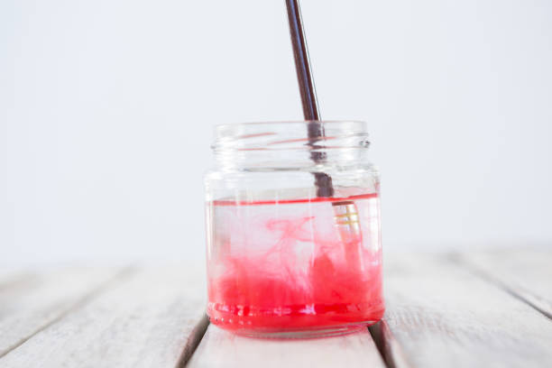 istock Paintbrush with red paint dipped into water 657689264