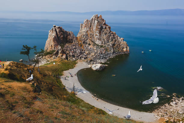 schöne aussicht auf den berühmten baikalsee in sibirien, russland, der größte süßwassersee nach volumen in der welt, olchon - larch tree stone landscape sky stock-fotos und bilder