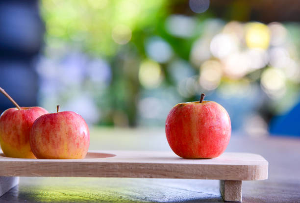 istock Group of red apples on wood tray on bokeh background 657708032