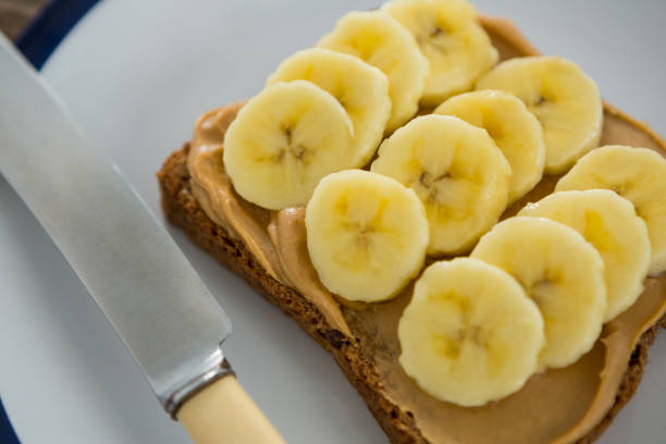istock Sliced bananas spread on brown bread in plate 657720934
