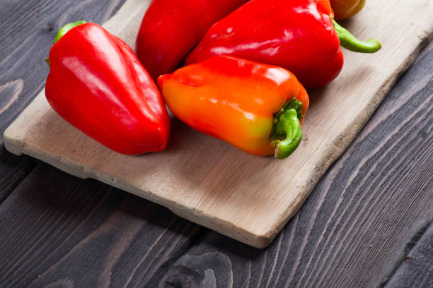 istock Sweet peppers on wooden cutting board 657730588