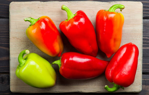 istock Sweet peppers on wooden cutting board 657730694