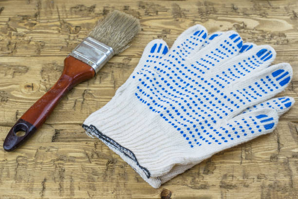 istock Brush with blue gloves on a wooden table. 657731084