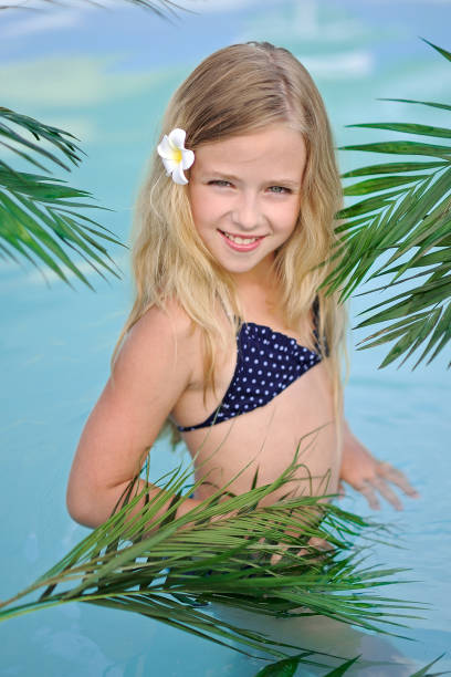 portrait of little girl in tropical style in a swimming pool - 16318 imagens e fotografias de stock