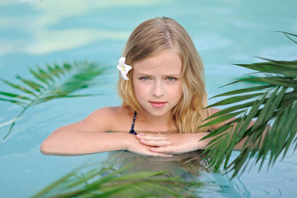 portret małej dziewczynki w tropikalnym stylu w basenie - 16319 zdjęcia i obrazy z banku zdjęć