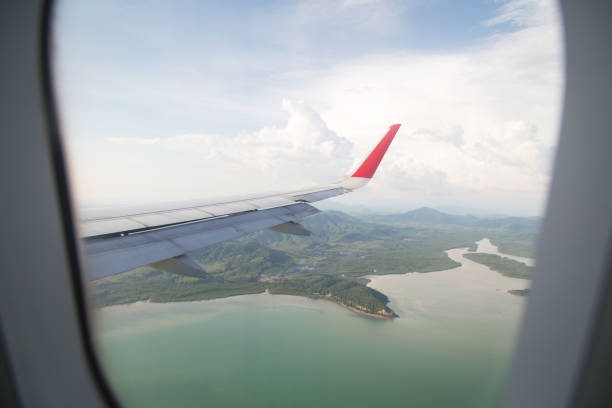istock Wing of an airplane flying above the ocean 657737128
