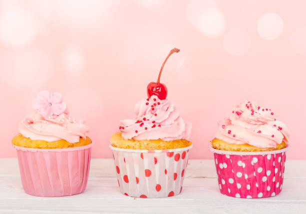 istock Row of three cupcakes with cream and decorations 657740372