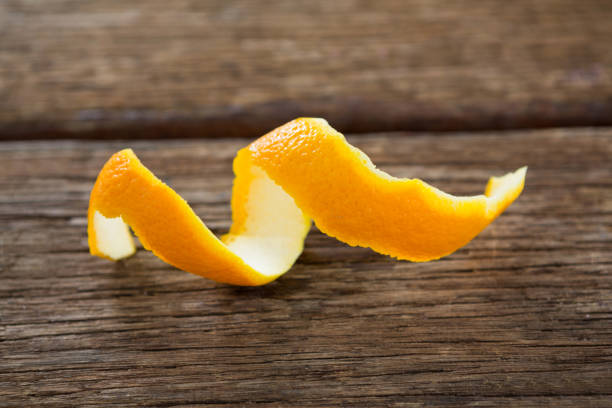 クローズ アップ スパイラル オレンジの皮をむく - close up women horizontal citrus fruit ストックフォトと画像