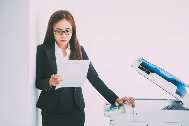 istock Asian Business Woman Reading Document at Copier 657747170