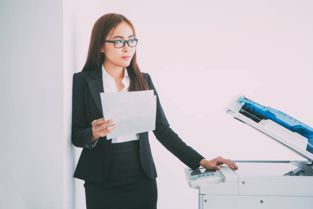 istock Pensive Business Woman at Copier with Document 657747344
