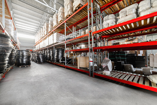 Warehouse industrial goods. Large long racks. Cardboard boxes and coiled plastic tube. Toning the image.