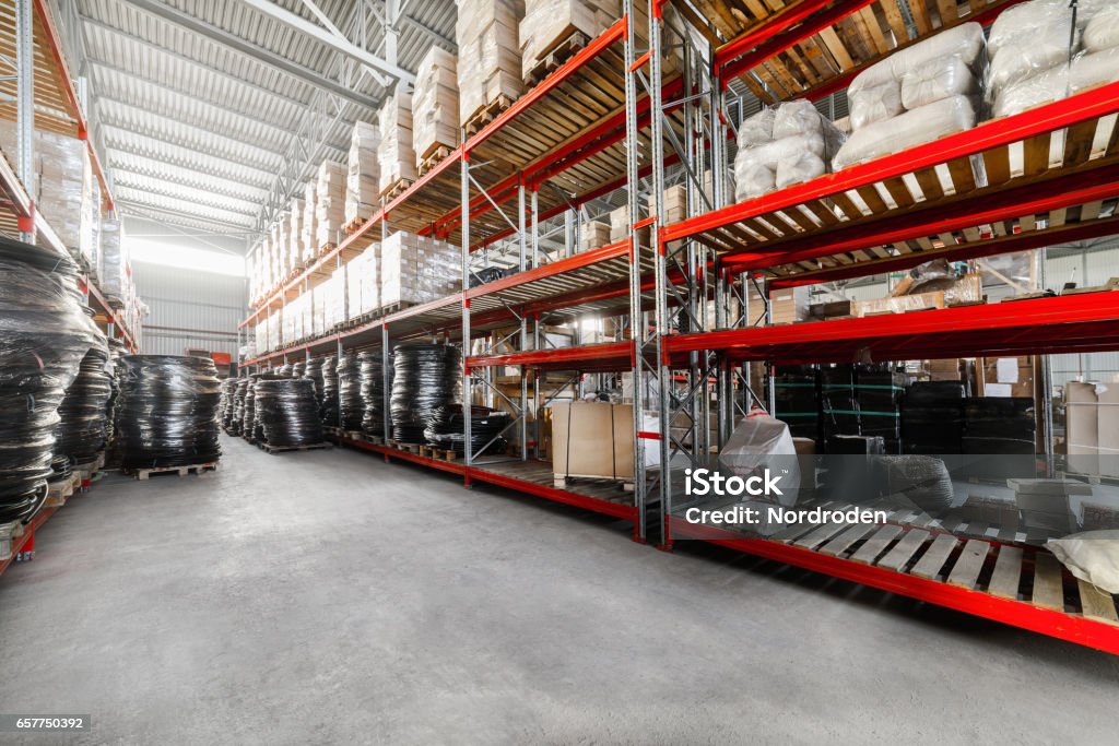 Long shelves with a variety of boxes and container Warehouse industrial goods. Large long racks. Cardboard boxes and coiled plastic tube. Toning the image. Warehouse Stock Photo