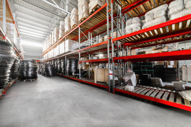 Long shelves with a variety of boxes and container Warehouse industrial goods. Large long racks. Cardboard boxes and coiled plastic tube. Toning the image. pvc conduit stock pictures, royalty-free photos & images