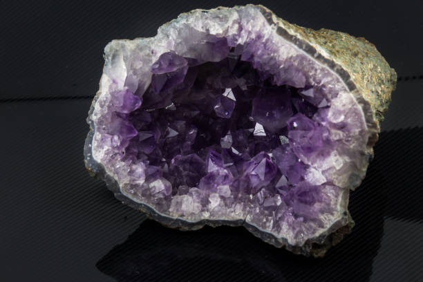 Beautiful semi-precious stone on amethyst druse a black background An attractive amazing mineral amethyst druse on a black glossy surface, from a personal collection of semi-precious stones and minerals Gemmary stock pictures, royalty-free photos & images