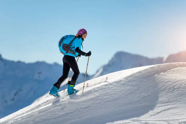 uphill girl with seal skins and ski mountaineering on the alps