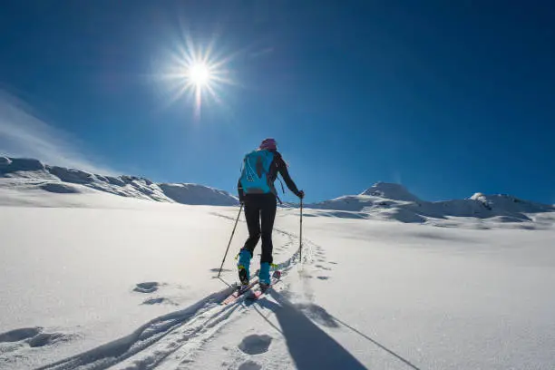 Uphill girl with seal skins and ski mountaineering in the alps