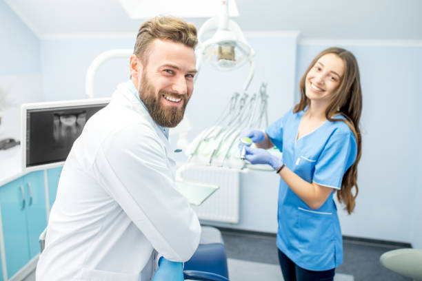 dentiste avec assistant chez le cabinet dentaire - dental assistent photos et images de collection
