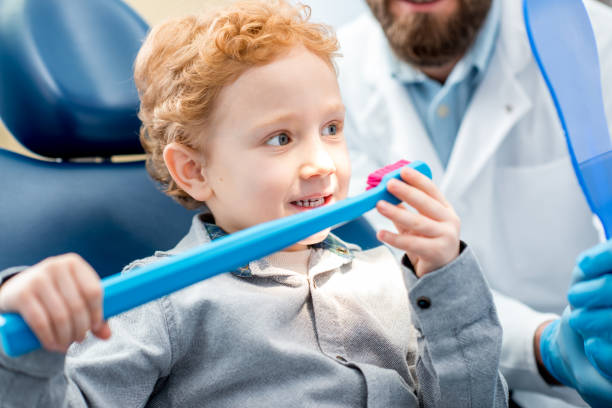 istock Boy with toothbrush at the dental office 657768610