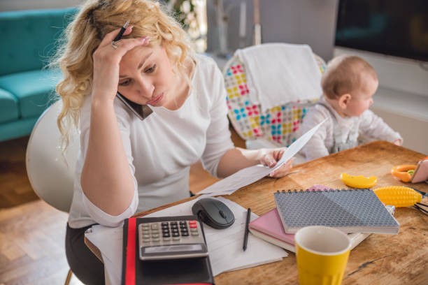 Mother talking on smart phone at home office