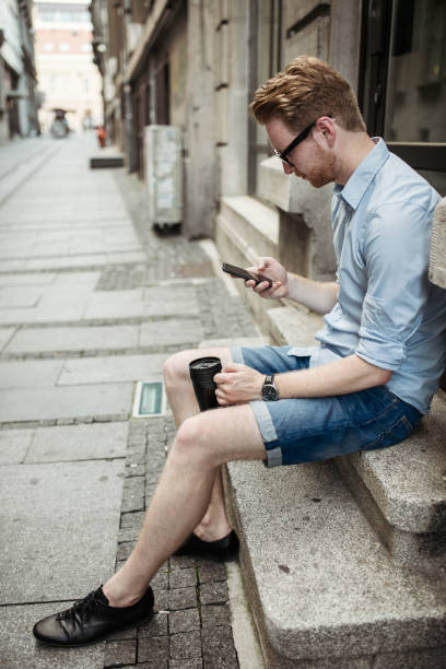 istock Redhead hipster reading books on his phone 657772050