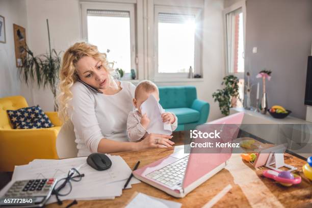 Mother Talking On Smart Phone At Home Office Stock Photo - Download Image Now - Mother, Emotional Stress, Multi-Tasking