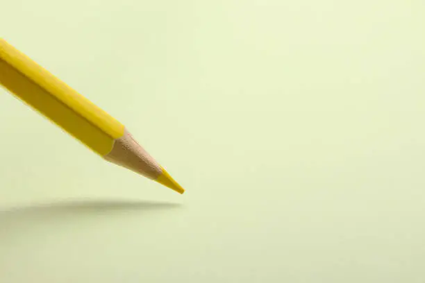 Yellow pencil is drawing on the blank background.