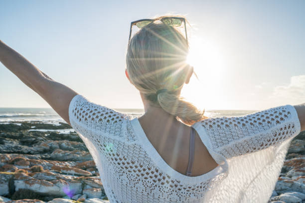 istock Young woman arms outstretched on beach, relaxation 657787844