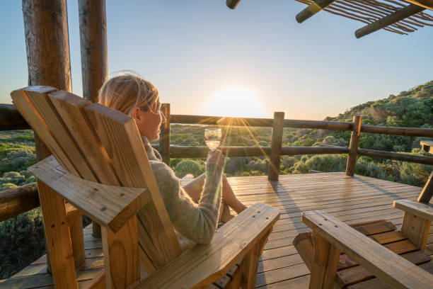 jovem mulher relaxante no terraço ao pôr do sol - casa de campo - fotografias e filmes do acervo