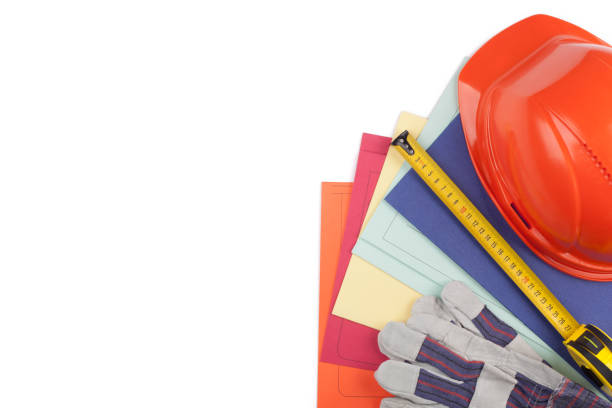 Protective helmet, gloves, tape measure and colored folders. stock photo