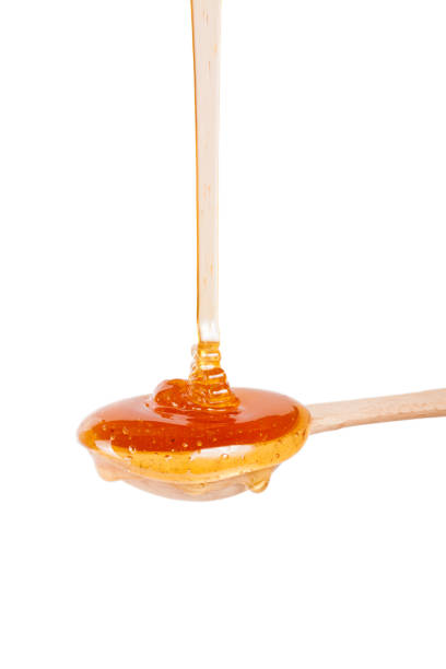istock Honey in a wooden spoon isolated on a white background 657804726