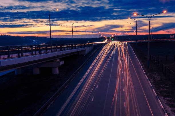 istock Moving car with blur light through twilight city bridge. 657815774