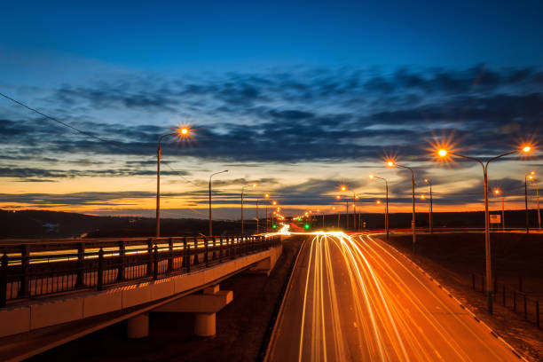istock Moving car with blur light through twilight city bridge. 657815782