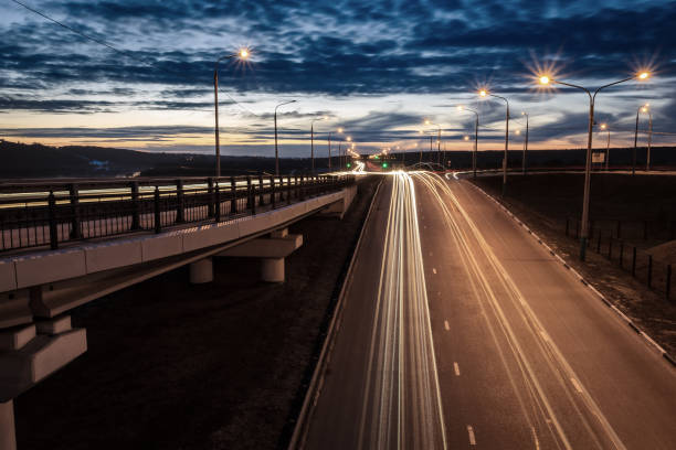 istock Moving car with blur light through twilight city bridge. 657815804