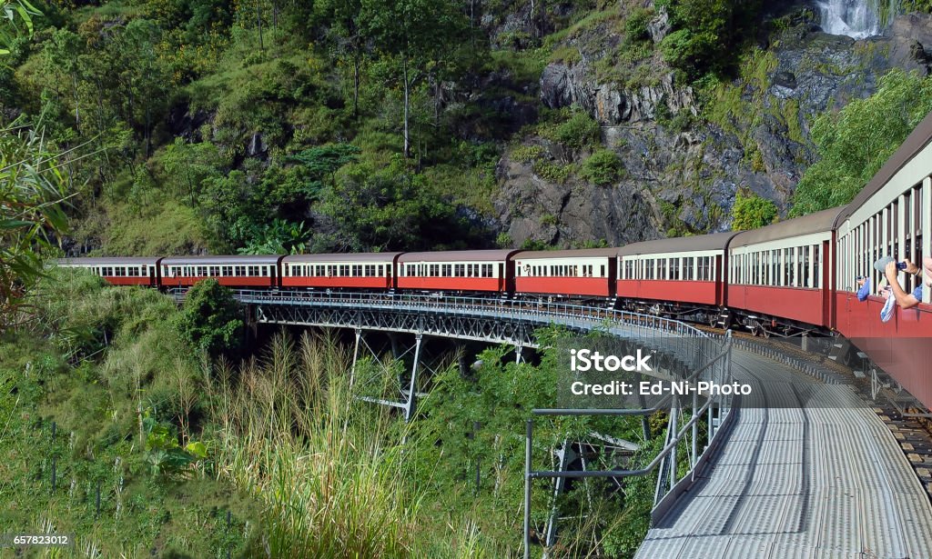 Scenic train turning a curve A scenic colorful train turns a curve with tropical vegetation background Kuranda Stock Photo
