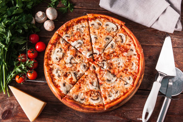 istock Fresh baked pizza with mushrooms on wooden table 657827294