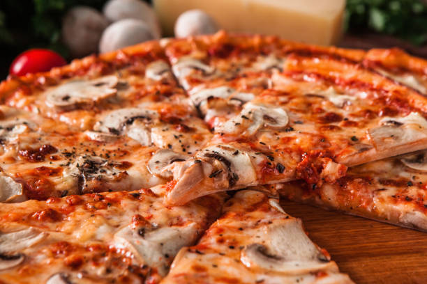 istock Fresh pizza cut in slices served on wood table 657827408