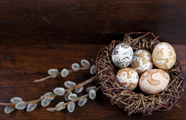 istock Easter theme. hand painted Easter eggs and willow branch with blossom on the wooden texture 657836590