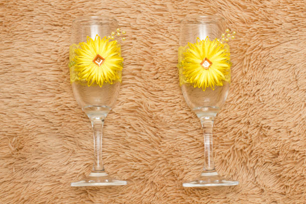 Spread of alcoholic beverages for celebration toasting at wedding reception. The waiter pours the champagne into the glasses. Table top full of glasses of sparkling white wine with bottles in the background.