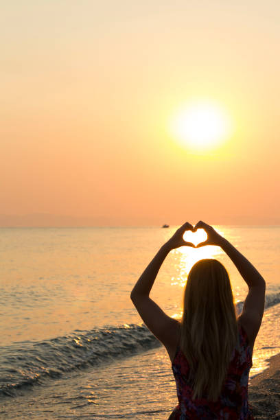 istock Young women making heart shape on beach 657851026
