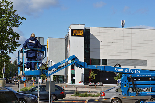 VILNIUS, LITHUANIA - MAY 17, 2016: Installation of new road signs at the intersection near Vingis movie theater. Center of the film is 11 cinema halls ( 2294 seats)