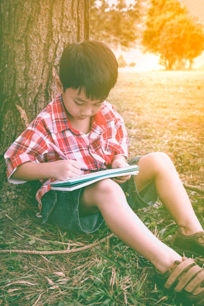 istock Boy writing on book. Education concept. Vintage style. 657868170