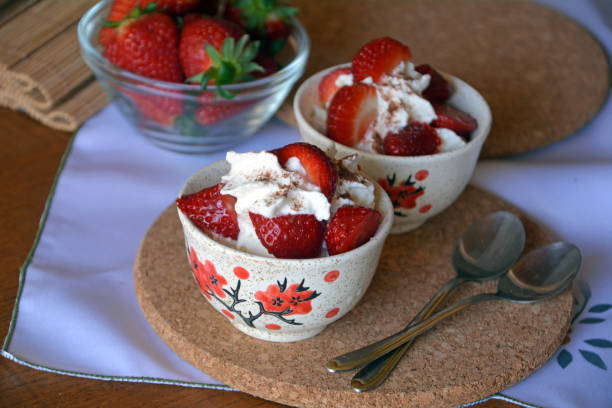 istock Fresh dessert chopped strawberries and whipped cream on a bowl. 657868976