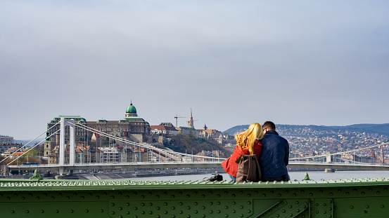 Budapest, Hungary, 25th of March, 2017 - A couple is sitting on the Liberty Bridge on a beautiful spring day.