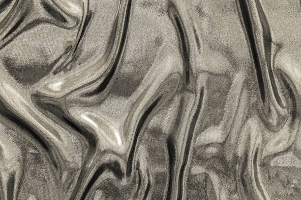 istock crumpled fabric of beige glossy color 657884382