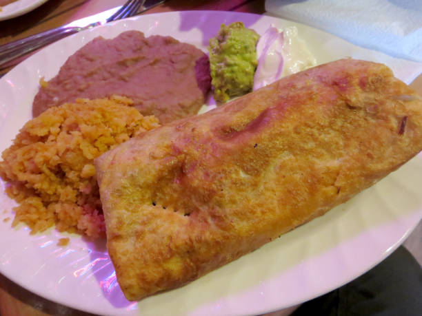 istock Chimichanga with spanish rice, beans, side guacamole, and sour cream 657889374