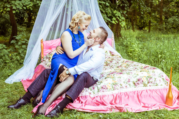 a couple on bed in meadow - 12014 imagens e fotografias de stock