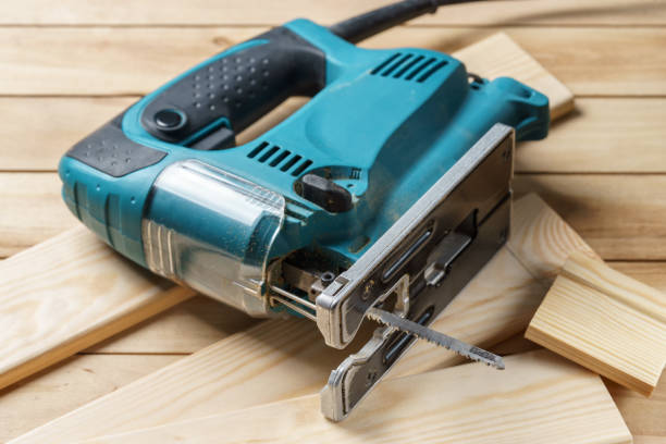 istock Electric jigsaw closeup On wooden table, work tools concept. 657914656