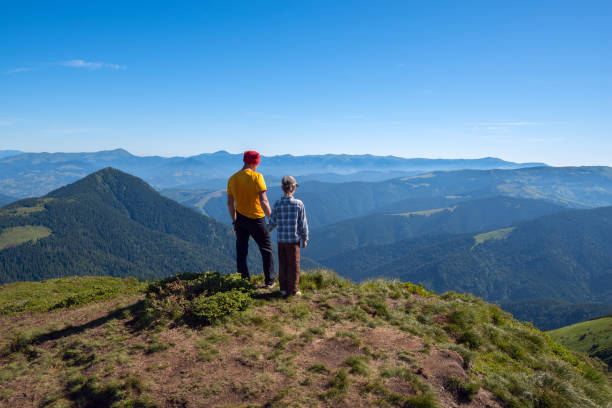 istock Father and son stand on peak and look into the distance 657918726