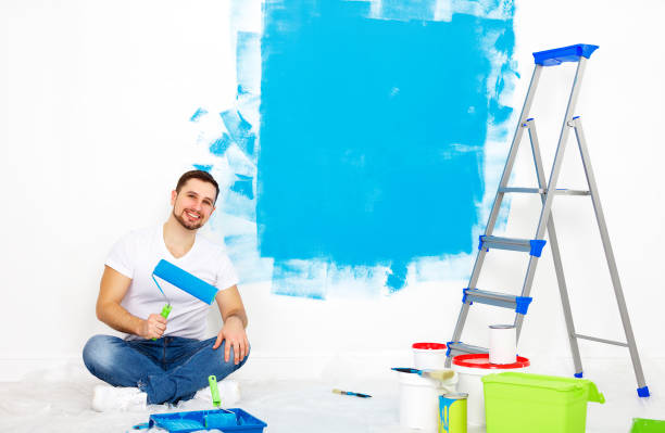 istock Repair in apartment. Happy man paints wall 657926222