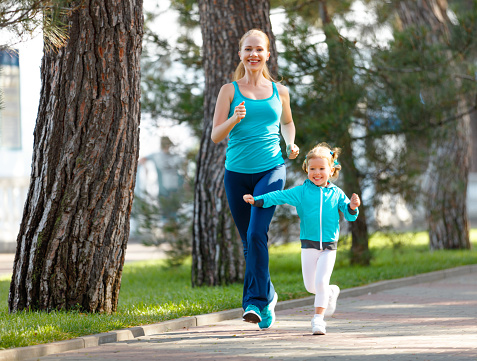 sport family. Mother and baby daughter jogging run on nature in summer